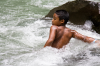 Costa Rica, La Fortuna: Junge badet in einer Stromschnelle
