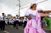 Costa Rica, La Fortuna: Frau mit rosanem,  wehendem Kleid auf Festumzug