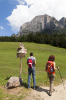 Italien, Sdtirol, Dolomiten: Zwei Wanderer orientieren sich bei bei einem Wegweiser 